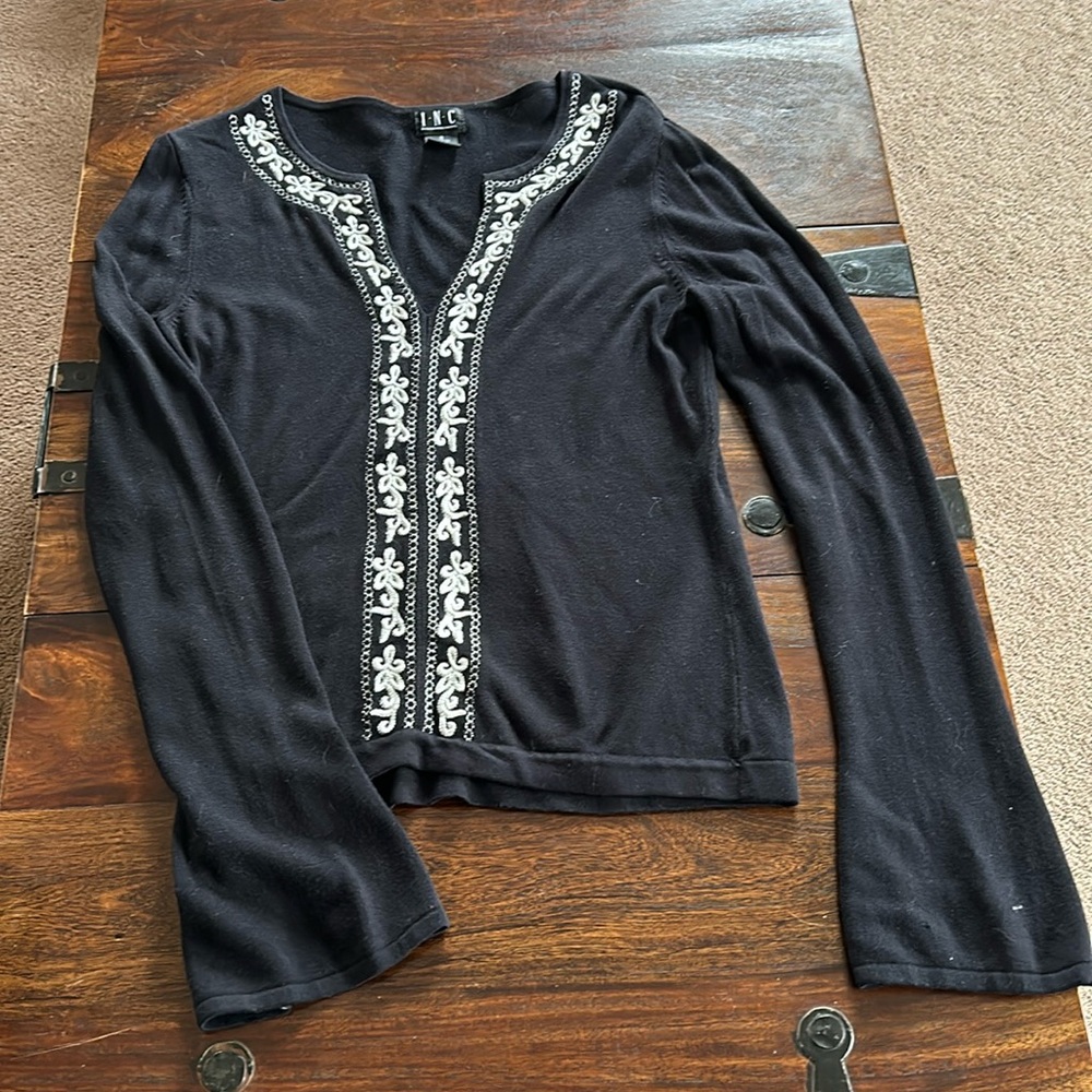 INC black sweater with white embroidery.